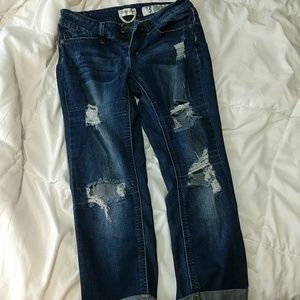 Ripped blue jeans rolled up at the bottom